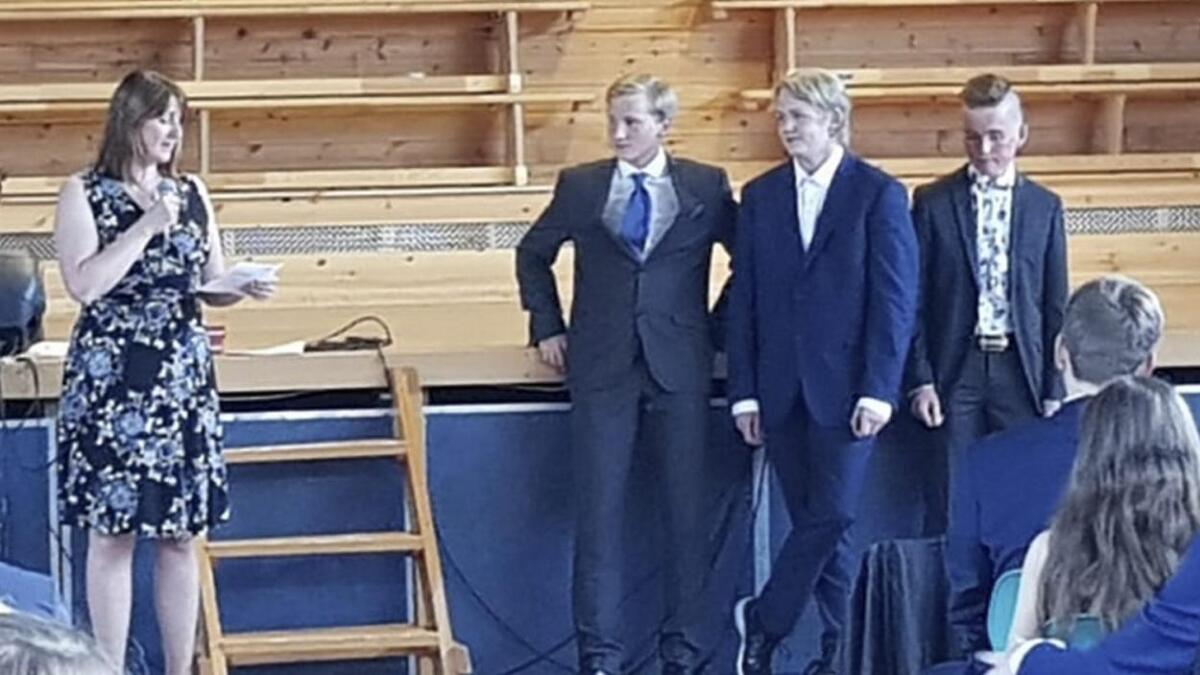 Fredrik Ulvatn (f.v.), Andreas Eik og Viljar Hanstvedt vart heidra av matematikklærar Jannicke Askeland foran ein fullsett gymsal på Os barneskule.