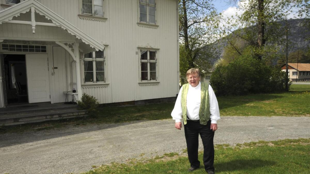 Sokneprest Øyvind Mæland (67) har sett stor pris på å kunne bu i prestegarden. Moland kyrkje og næringshagen er i bakgrunnen. 	Båe