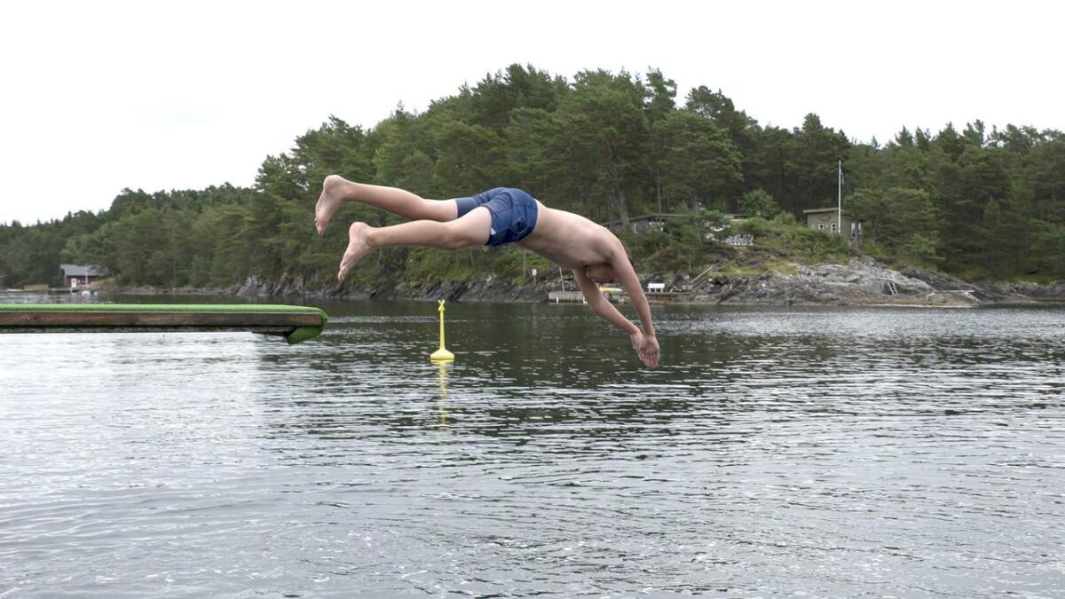 Kaster Aarø (12) let seg ikkje hindre av den kjølige vinden når han stupar uti sjøen på Kallneset. - Det er mykje varmare i sjøen enn på land, meinar han.