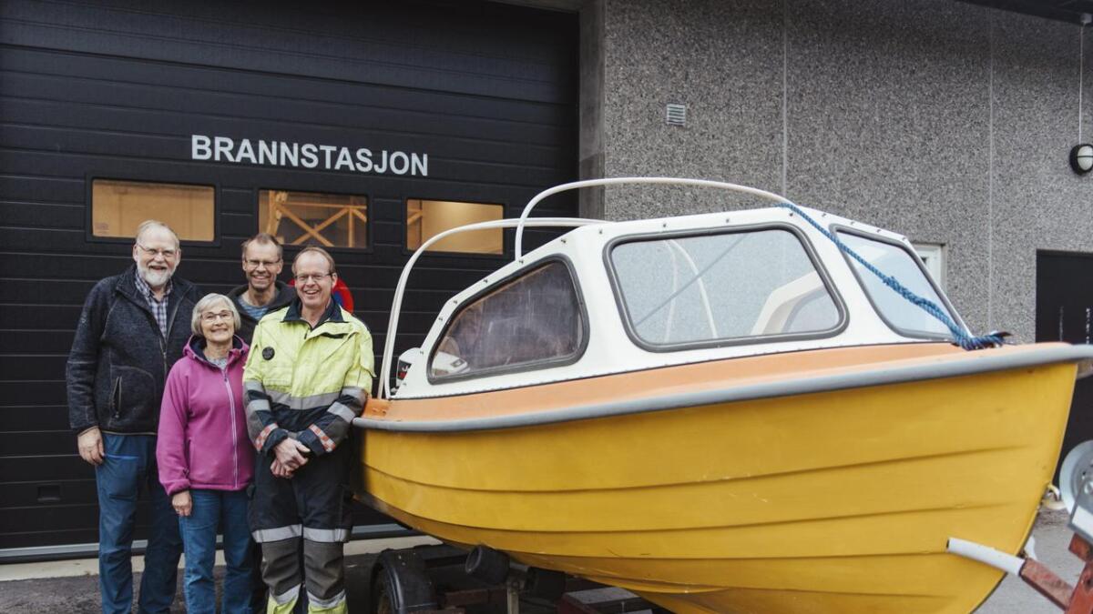 Ragnvald og Birgit Christenson ved båten dei har gjeve til brannstasjonen i Haukeli representert av beredskapsleiar i Vinje kommune, Olav Ringhus, og utrykkingsleiar i Haukeli, Arnulf Elgen.