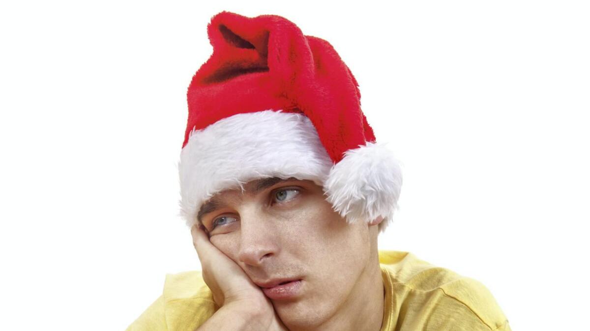 Sad Young Man in Santa Hat Isolated On The White Background