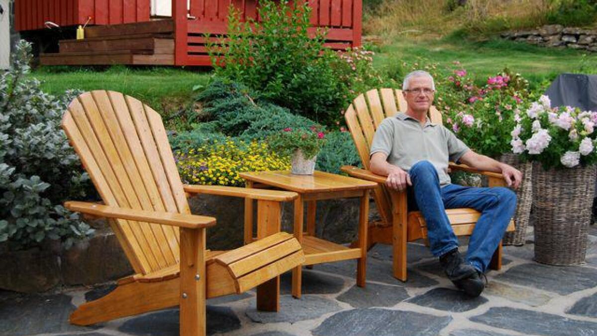 Knut Østreim sitter godt i Adirondack-hagestolen som han produserer i sitt verksted på Ørsland i Høvåg.