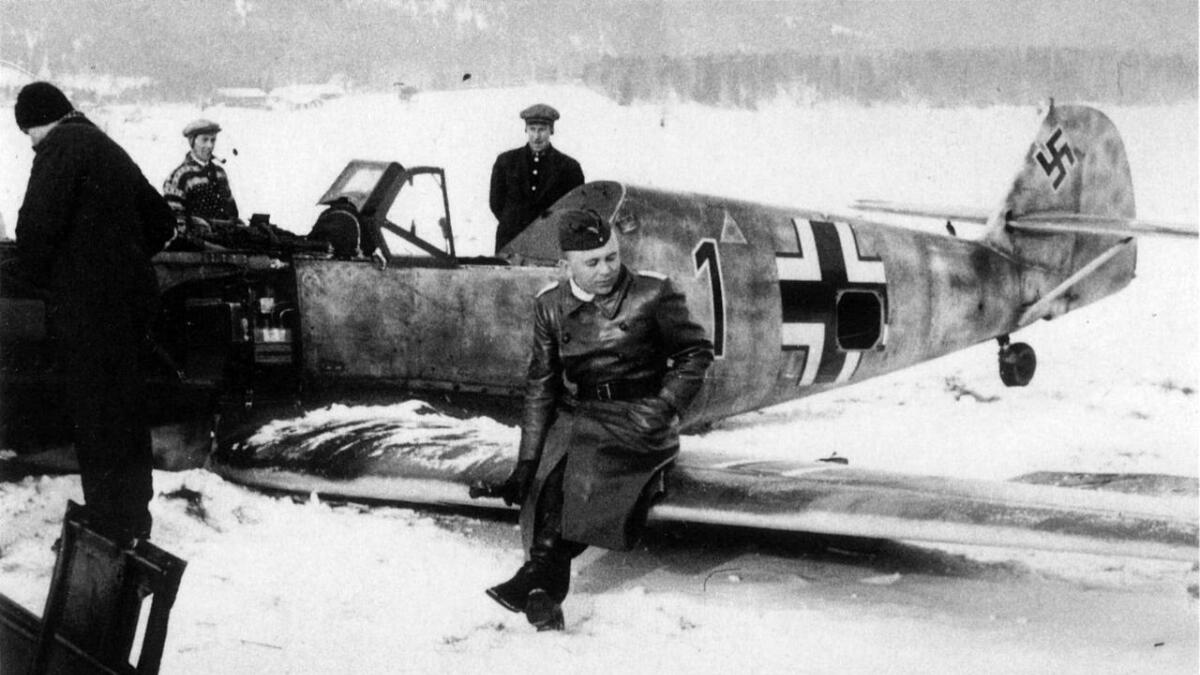 Ein mogeleg mellomfornøgd hauptmann Werner Dolenga på vengen av Messerschmitt-flyet ute på elveisen. I bakgrunnen Erik Østensen og Olaf Bæken.