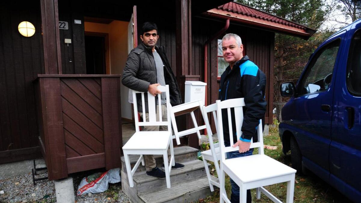 Flyktningkoordinator Olav Thoen og medhjelpar Ismaiel Alokozai ber inn møblar i bustadhuset på Rødberg som ein syrisk familie flyttar inn i denne veka.