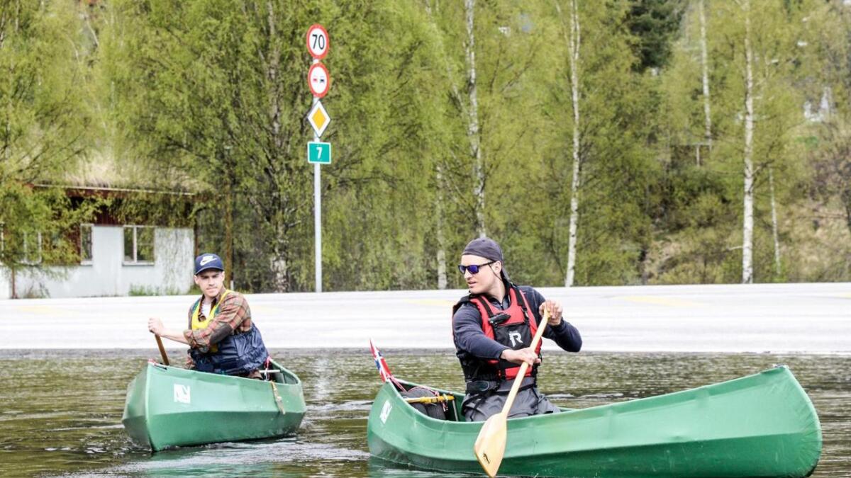 Håkon Kristiansen og Martin Ødegård starta på Gol og har mål om å padle til Gulsvik. Her kryssar dei vegen ved shell på Nes, utan møtande trafikk då Rv7 var flaumstengt.