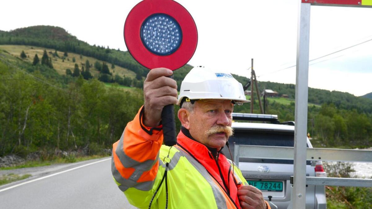 Øyvind Brenno regulerer trafikken medan det blir utført arbeid på vegen.