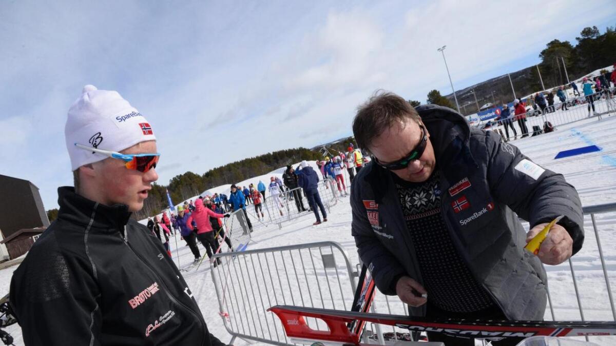 Gabriel Johannessen har over 40 års erfaring frå skisporten. Her smør han skia til Emil Intelhus Brøto i samband med eit skirenn på Geilo.