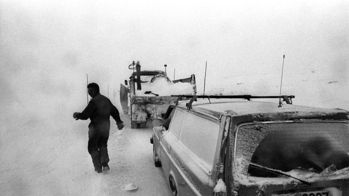 Ein bil står fast og må hjelpast laus av brøytebilen. Rv7 over Hardangervidda.