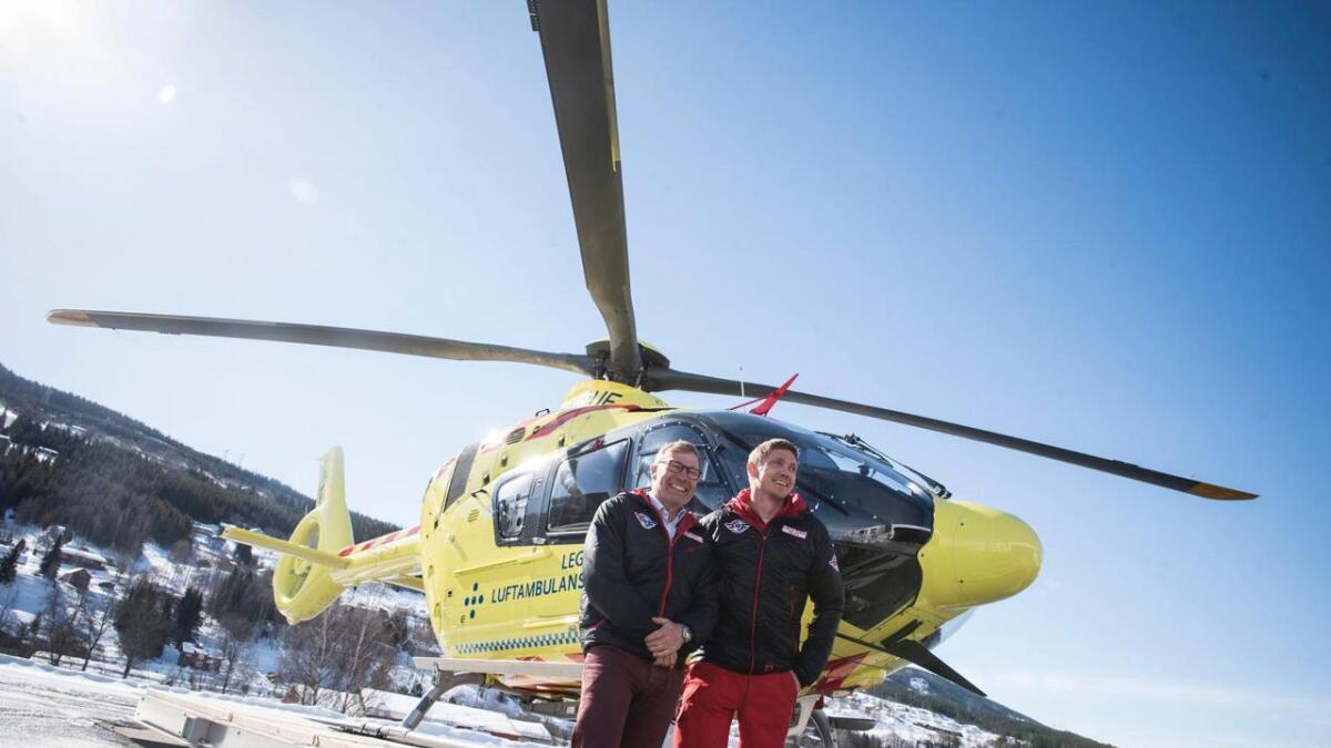 Rune Midtgaard (t.v.) og pilot Lukas Olsen poserer framfor det nye helikopteret.