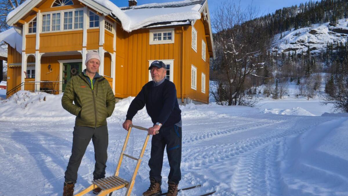 Jegeir Trøim og faren Knut Trøim på gardstunet der mange generasjonar før dei har drive som bønder.