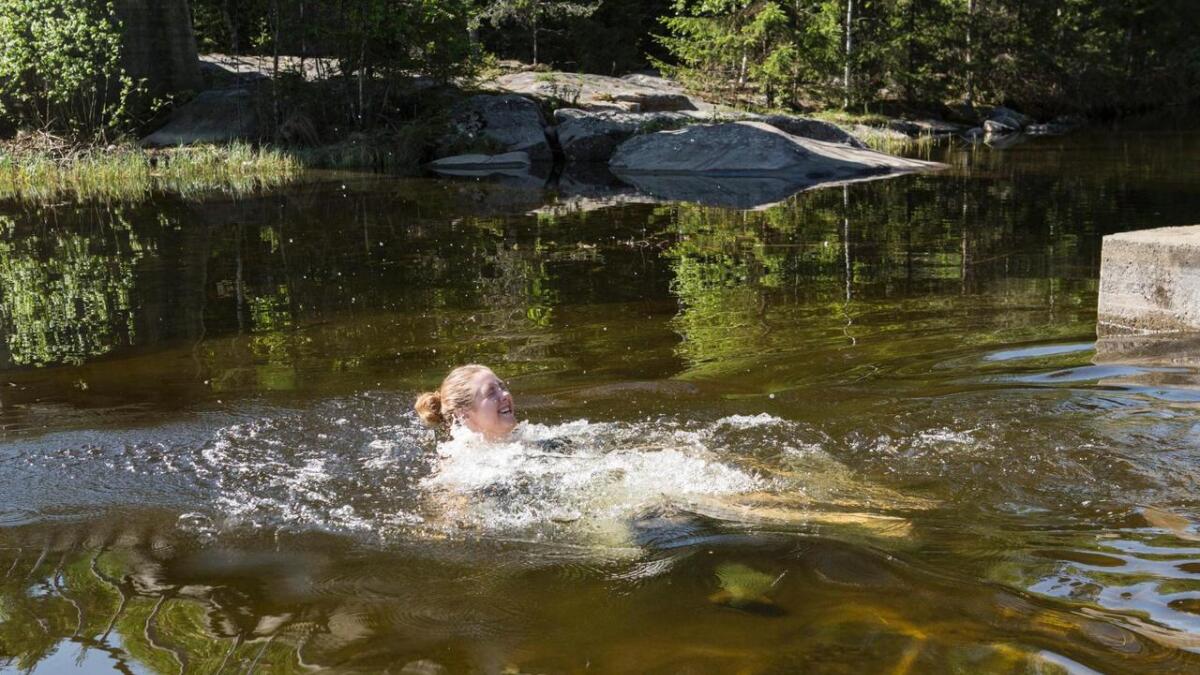 Kristine Viko testa badetemperaturen i Hallingdalselva ved Mobrua.