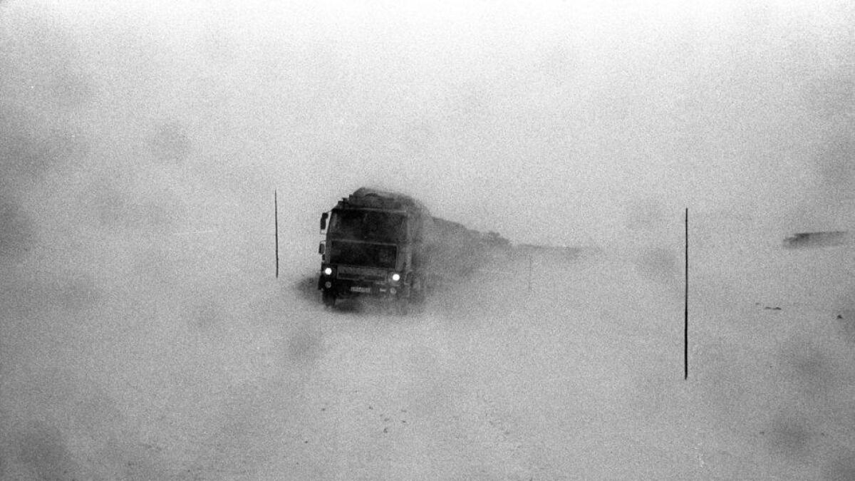 Eit vogntog sneglar seg fram gjennom snøføyka. Rv7 over Hardangervidda.
