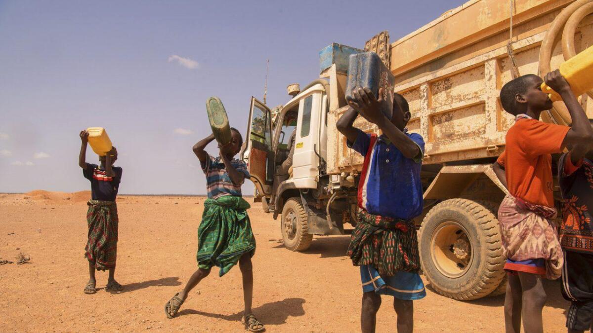 Gutar som drikk vatn i landsbyen Baarweyn i Puntland utenfor Garowe, Somalia. Gutane er mellom 6 og 10 år, og går 12 kilometer for å hente 3 liter vann. Her har Kirkens Nødhjelp nett kome med vatn i tankbil.